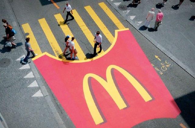 Sotto a delle striscie pedonali viene dipinta la confezione iconica di McDonald's, che le trasforma in patatine